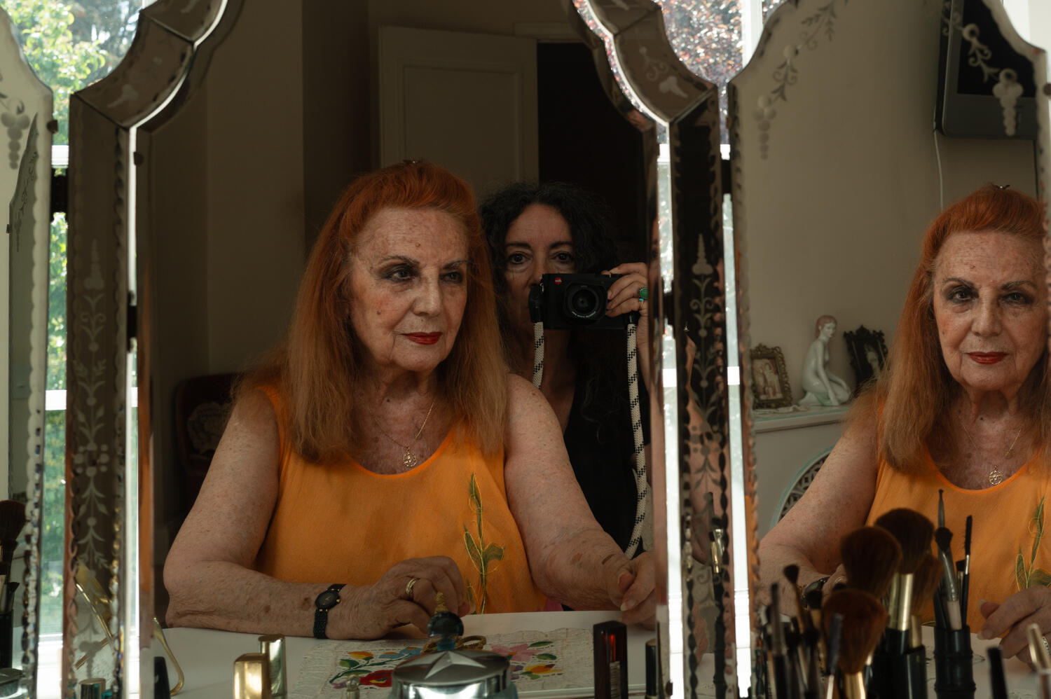 My 88 year old mother Dalia at her dressing table, 2025 with me in the picture